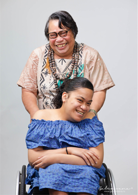 Young lady in her wheelchair with her mother standing behind her